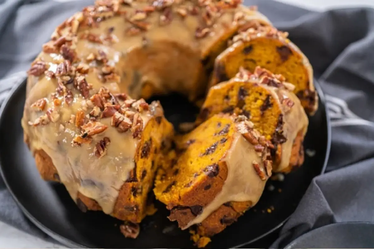 A vintage Bundt pan placed on a wooden table, showcasing its intricate design and durable craftsmanship